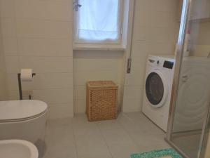 a bathroom with a toilet and a washing machine at Attico vista mare in Levanto