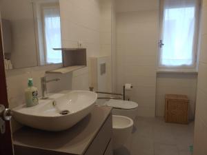 a white bathroom with a sink and a toilet at Attico vista mare in Levanto