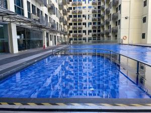 a large blue swimming pool in a building at Kk homeStay City suites Room Ming Garden Residence in Kota Kinabalu