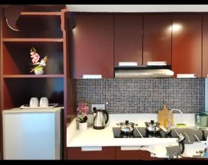 a kitchen with brown cabinets and a white counter top at Kk homeStay City suites Room Ming Garden Residence in Kota Kinabalu