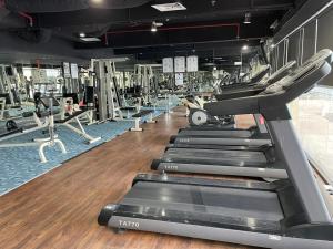 a gym with rows of treadmills and machines at Kk homeStay City suites Room Ming Garden Residence in Kota Kinabalu