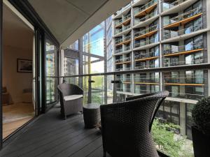 un balcone con 2 sedie e un edificio di Riverside Oasis walk to Battersea Power Station a Londra