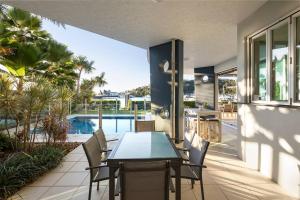 a patio with a table and chairs and a pool at Pavillions 17 Waterfront with Private Pool and Buggy in Hamilton Island