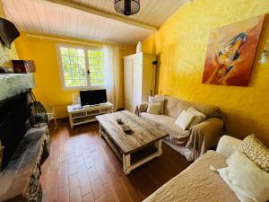 uma sala de estar com um sofá e uma mesa de centro em Les Mille Mimosas em Les Assions