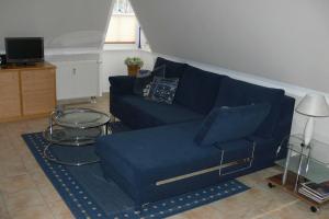 sala de estar con sofá azul y mesa en Villa Ambienta, en Binz