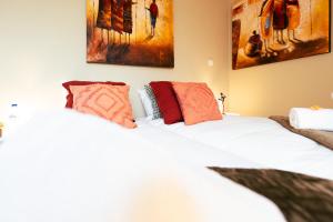 2 camas en una habitación con pinturas en la pared en Lets Relax - Terre d'Afrique, en Mons