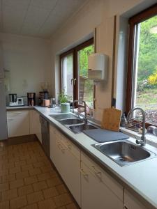 a kitchen with two sinks and a window at Haus Nirgendwo in Lützkampen