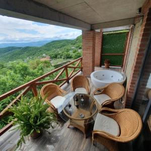 a balcony with a table and chairs and a bath tub at Villa Vejini in Mamkoda