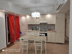 eine Küche mit weißen Schränken sowie einem Tisch und Stühlen in der Unterkunft Romantic house posto auto aria condizionata in Bologna
