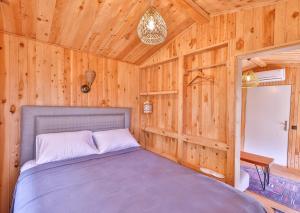 um quarto com uma cama num quarto de madeira em Sedir Taş Evleri em Kalkan