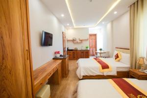 a hotel room with two beds and a television at Selima Hotel in Quy Nhon +33 photos