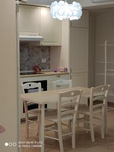eine Küche mit einem Tisch, Stühlen und einer Leuchte in der Unterkunft Romantic house posto auto aria condizionata in Bologna