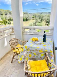 een tafel en stoelen op een balkon met een tafel met citroenen bij Domus Lucae in Leuca