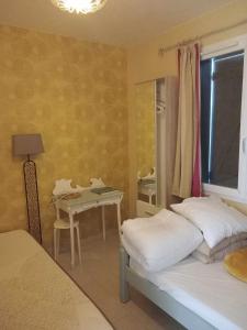 1 Schlafzimmer mit 2 Betten und einem Tisch mit einem Spiegel in der Unterkunft Un bouquet de Tangissart in Villepinte