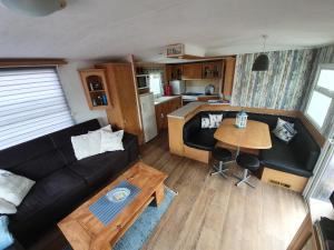 ein Wohnzimmer mit einem Sofa und einem Tisch in der Unterkunft Meer-Brise in Burgh Haamstede