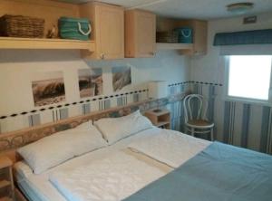 een slaapkamer met een bed en een raam bij Meer-Brise in Burgh Haamstede