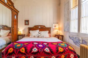 1 dormitorio con 1 cama grande y edredón rojo en Tía Angelina, Hogar Noucentista en Sant Hilari Sacalm
