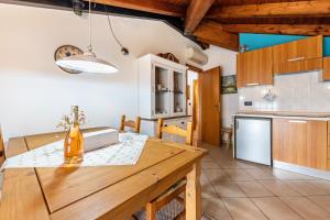 uma cozinha e sala de jantar com uma mesa de madeira em Appartamento piccionaia sul lago em Gargnano