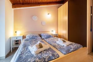 um quarto com 2 camas com lençóis azuis e brancos em Appartamento piccionaia sul lago em Gargnano