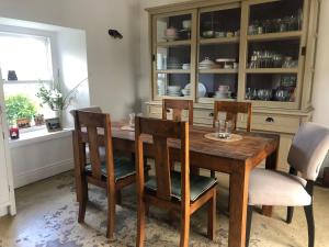 comedor con mesa de madera y sillas en Restored Historic House in Clare, en Ennis
