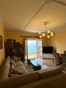 a living room with a couch and a view of the ocean at Levi's Villa Radhima in Vlorë