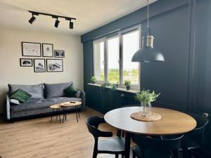 a living room with a table and a couch at Apartament Przytulny 5 - Las, self check in, dworzec PKP in Rzeszów