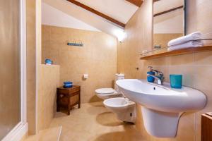 uma casa de banho com um lavatório e um WC em Appartamento piccionaia sul lago em Gargnano