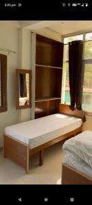 een slaapkamer met 2 bedden en een raam bij Badrinath Govindghat Prithvi yatra hotels in Badrīnāth