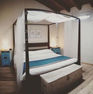 um quarto com uma cama de dossel e piso em madeira em B&Be Happy em Civo