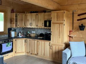 a kitchen with wooden cabinets and a tv in a room at Domek góralski Cudna izba in Witów