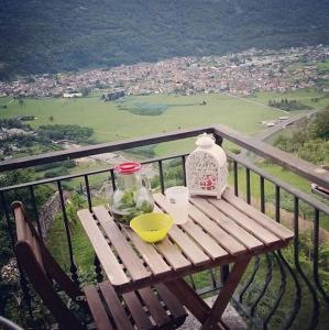 uma mesa de madeira com uma tigela e um jarro na varanda em B&Be Happy em Civo