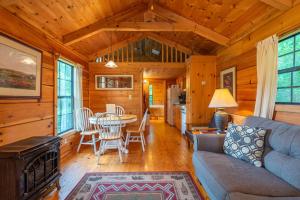 a living room with a couch and a table in a cabin at Engadine Inn and Cabins in Candler