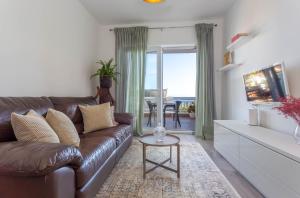 uma sala de estar com um sofá de couro castanho e uma mesa em Hvar Pavičić Top View apartments em Hvar