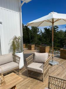 eine Terrasse mit 2 Stühlen und einem Sonnenschirm in der Unterkunft Hytteperle in Risør