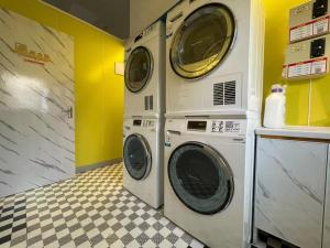 Duas máquinas de lavar e secar roupa numa lavandaria em Magnificent International Hotel em Xangai