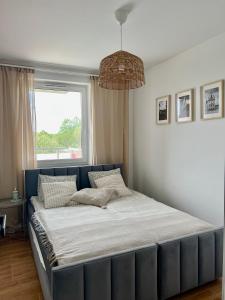 1 cama grande en un dormitorio con ventana en Apartament Przytuly 4, self check in, parking, blisko lotniska, en Rzeszów