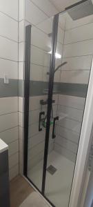 a shower stall with a glass door in a bathroom at Ô2J in Fresse