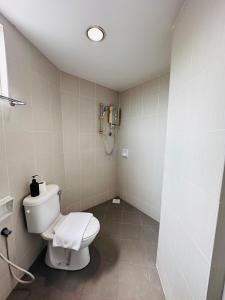 ein Bad mit WC und ein Telefon an der Wand in der Unterkunft Your Hotel Klang in Klang