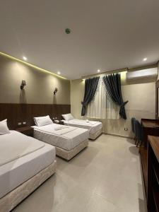 um quarto de hotel com duas camas e uma secretária em Sama hotel no Cairo