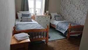 2 camas individuales en una habitación con ventana en Le Black Dog Pub, en Saint-Aignan