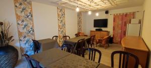 a dining room with tables and chairs and a television at Ô2J in Fresse