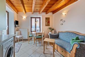 uma sala de estar com um sofá azul e uma mesa em Appartamento Buon Riposo em Gargnano
