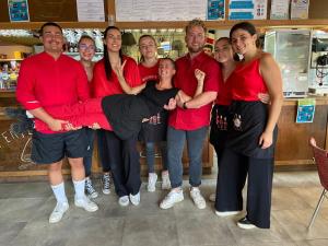 grupa ludzi w czerwonych koszulkach pozujących do zdjęcia w obiekcie Camping Le Perpetuum w mieście Domme