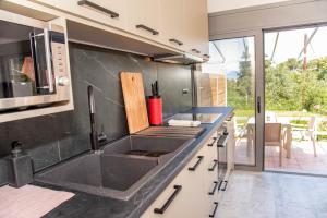 a kitchen with a sink and a microwave at Gems Suites in Corfu Town +40 photos