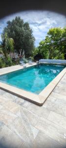 una piscina de agua azul en un patio en Superbe appartement classé 4 étoiles - le Boulou, en Le Boulou
