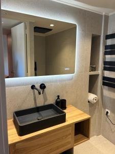 baño con lavabo negro y espejo en Vue magnifique, en Niza