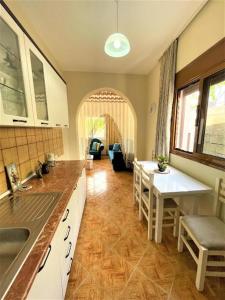eine Küche mit einem Waschbecken und einem Tisch mit Stühlen in der Unterkunft Villa Allegri in Vlorë