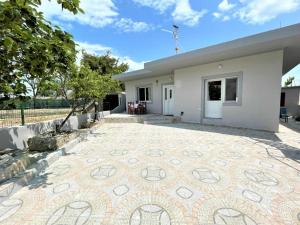 una casa con un patio de azulejos frente a ella en Villa Allegri en Vlorë