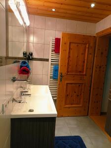 a bathroom with a sink and a wooden door at Ferienhaus Innerzarge in Tux