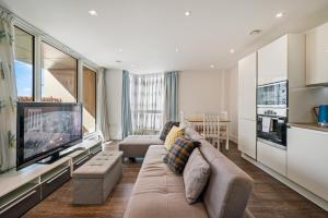 a living room with a couch and a flat screen tv at Spacious Modern 1-Bedroom Flat in Central London in London